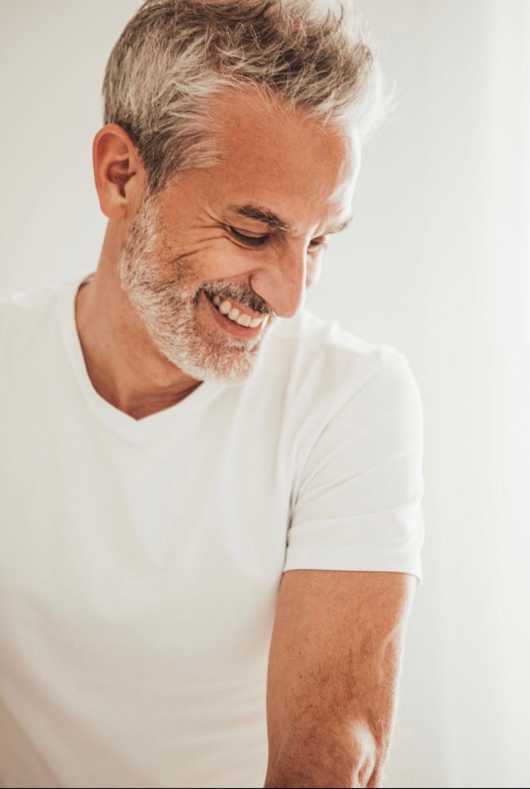 Portrait de Lionel Jourdan, souriant, en tenue blanche
