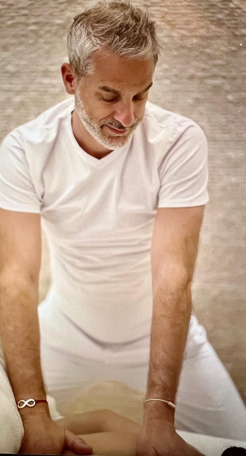 Lionel Jourdan pendant un massage, en tenue blanche